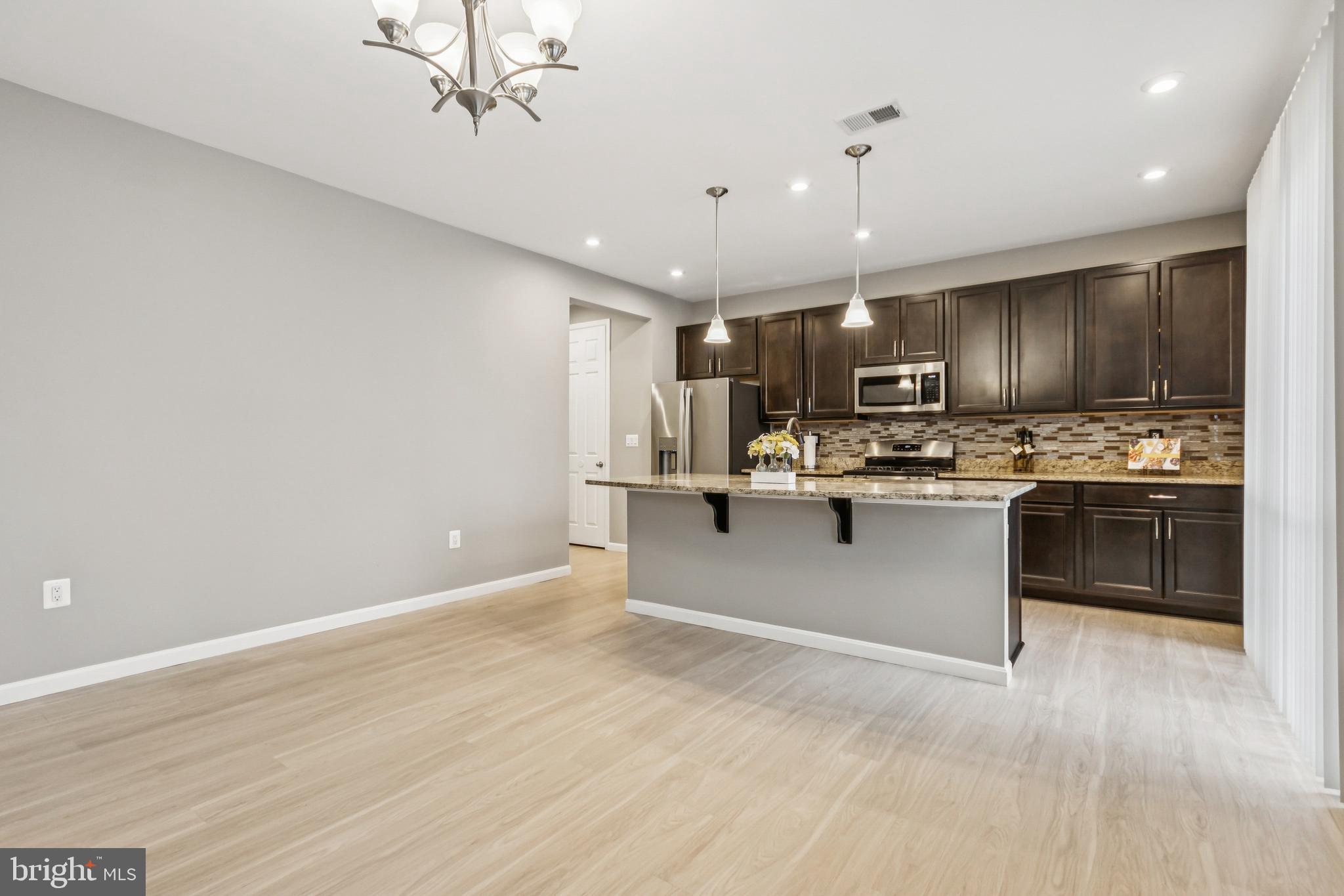 7252 Liberty Court Ruther Glen, VA 22546 - Photo 12 of 45 a kitchen with stainless steel appliances kitchen island granite countertop a refrigerator stove top oven and cabinets