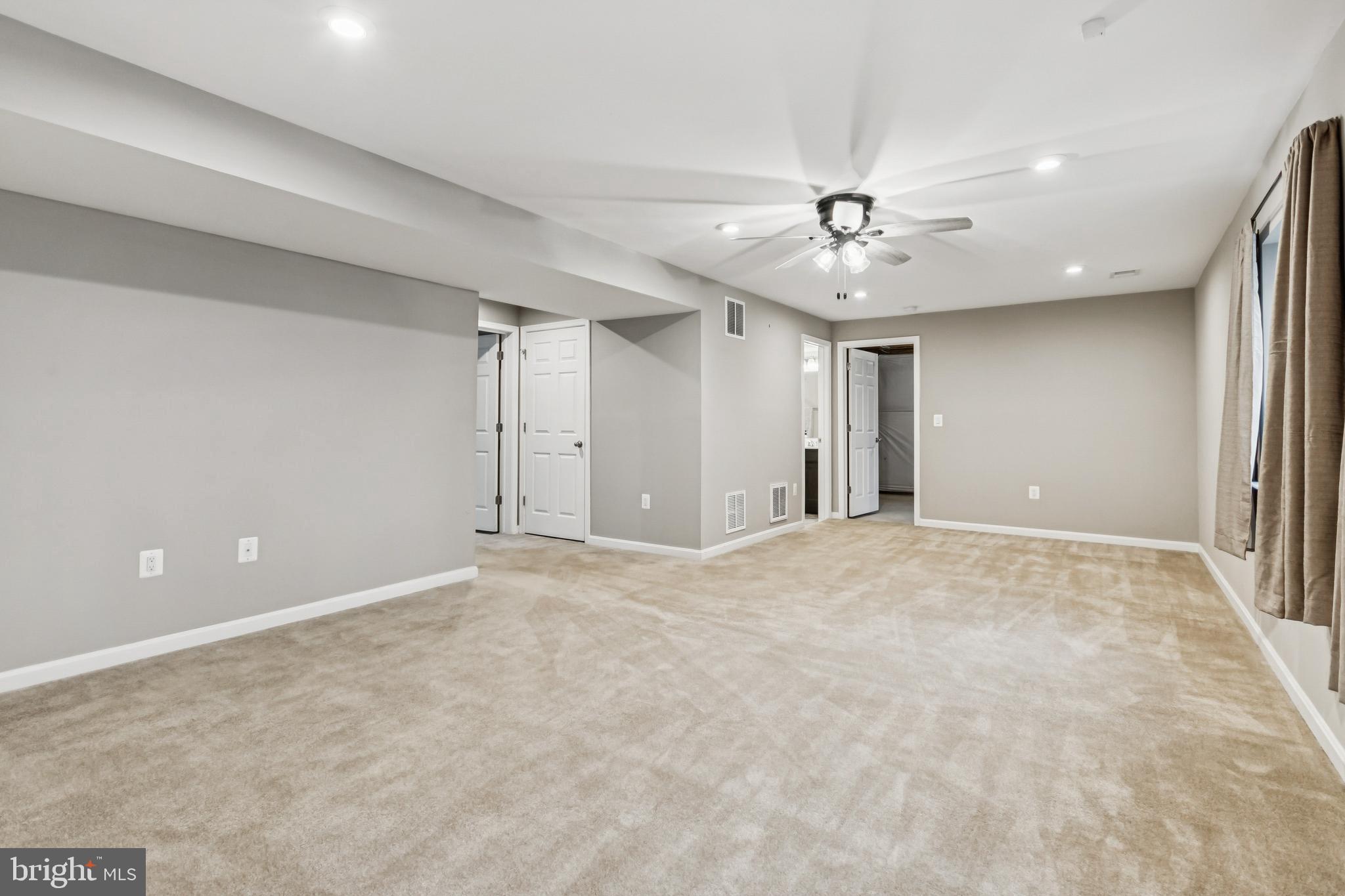 7252 Liberty Court Ruther Glen, VA 22546 - Photo 35 of 45 an empty room with chandelier fan and windows