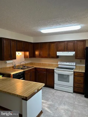 a kitchen with granite countertop a stove and a sink