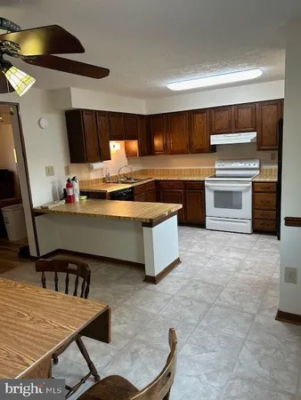 a kitchen with a stove a refrigerator and furniture