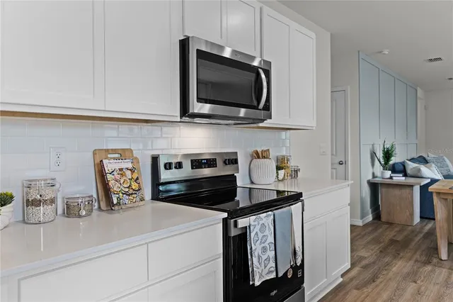 a kitchen with a microwave a stove and cabinets