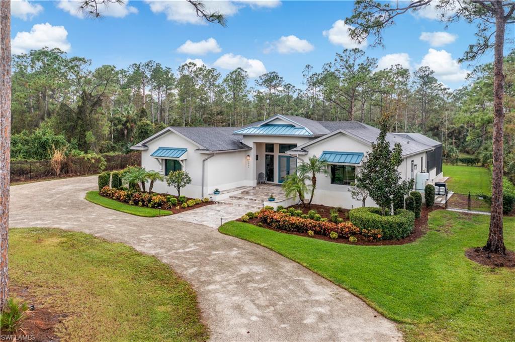2991 2nd Street Northwest Naples, FL 34120 - Photo 2 of 43 a view of a white house with a big yard and potted plants