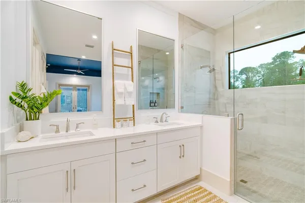 a bathroom with a double vanity sink mirror and shower