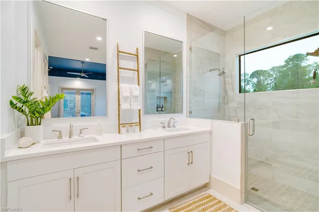 a bathroom with a double vanity sink mirror and shower
