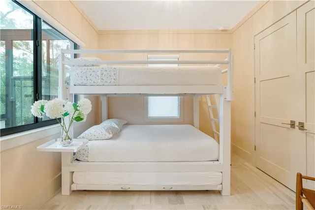 a bedroom with a bed potted plant on the dresser and floor