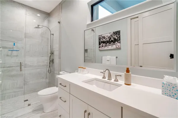 a bathroom with a sink a toilet and shower