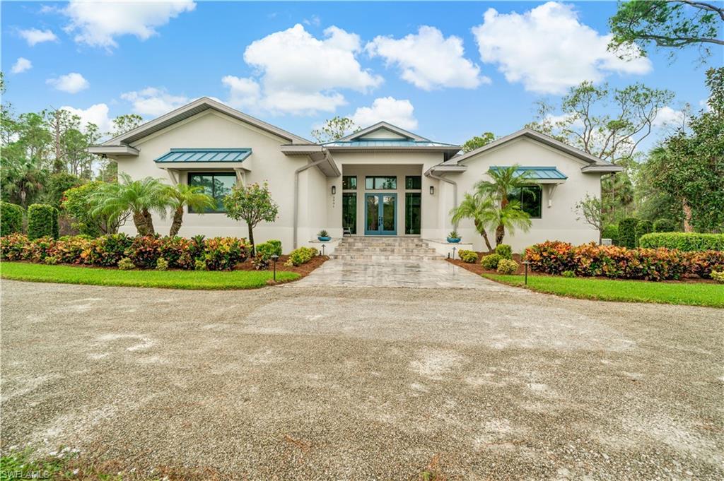 2991 2nd Street Northwest Naples, FL 34120 - Photo 3 of 43 a front view of a house with a garden