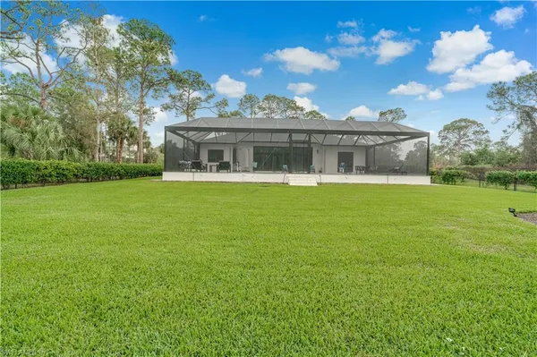a view of a house with a big yard and a large tree