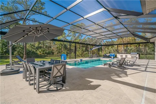 a view of a patio with a table and chairs under an umbrella