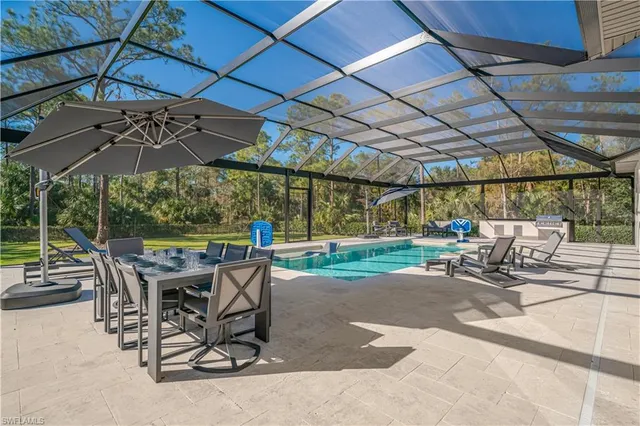 a view of a patio with a table and chairs under an umbrella