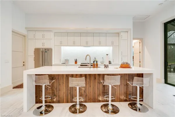 a kitchen with a sink a table and chairs