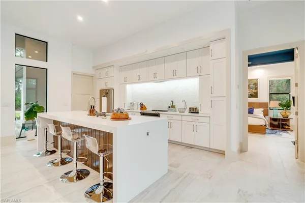 a kitchen with a sink and chairs