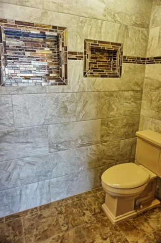 a bathroom with a toilet and a shower