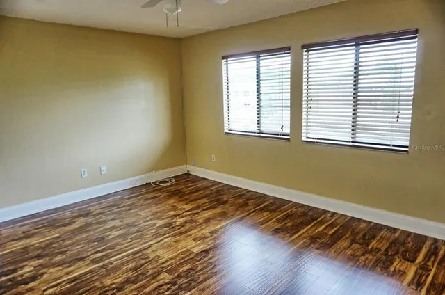 a view of a room with wooden floor and a window
