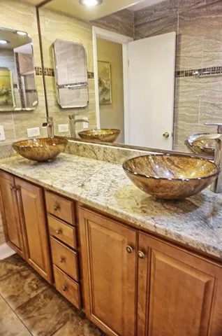 a bathroom with a granite countertop sink and a mirror