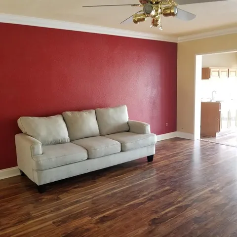 a living room with furniture and a wooden floor