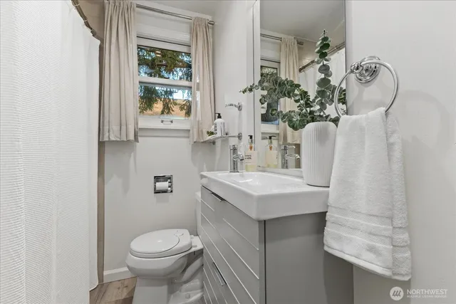 a bathroom with a sink toilet and window