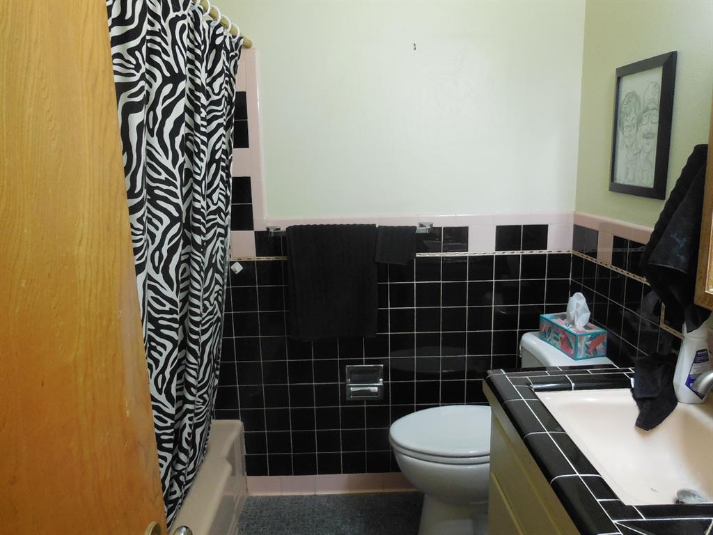 209 Breckenridge Road Ranger, TX 76470 - Photo 13 of 21 a bathroom with a sink a toilet and a mirror