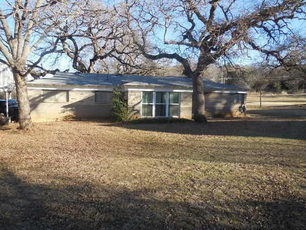 a front view of house with yard and trees around