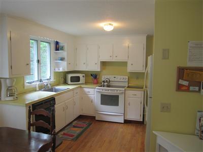 a kitchen with a sink cabinets and wooden floor