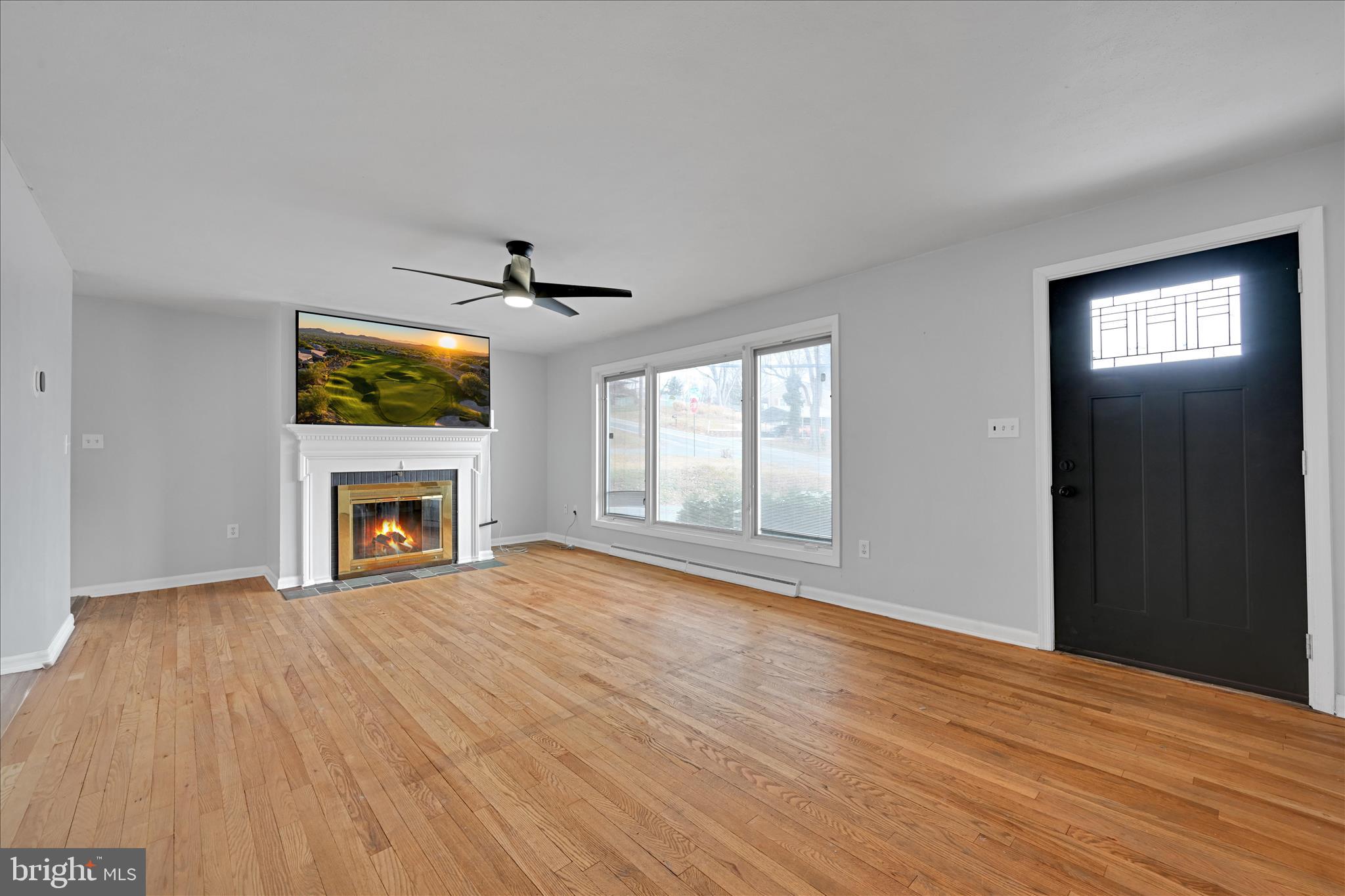 465 Pleasant View Road New Cumberland, PA 17070 - Photo 8 of 31 wooden floor fireplace and windows in an empty room
