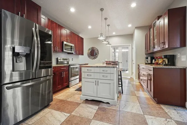 a kitchen with stainless steel appliances granite countertop a stove a sink and a microwave