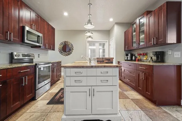 a kitchen with stainless steel appliances granite countertop a sink stove and microwave