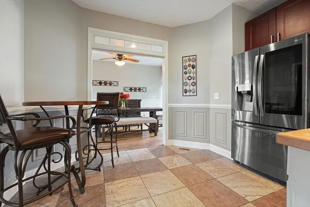 a dining room with wooden floor a chandelier a glass table and chairs