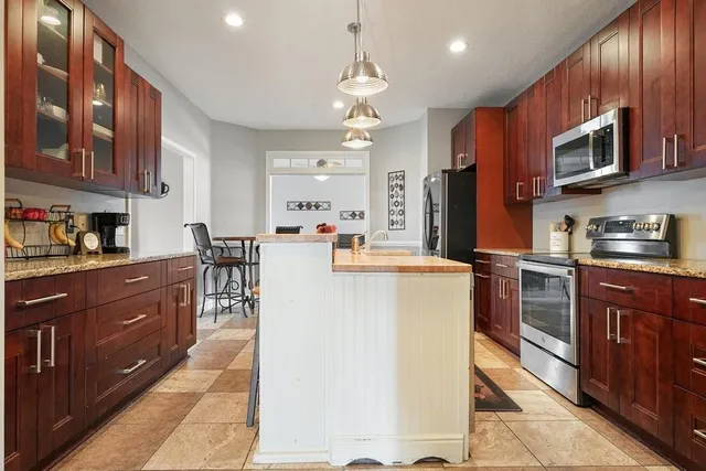 a kitchen with a sink refrigerator and cabinets