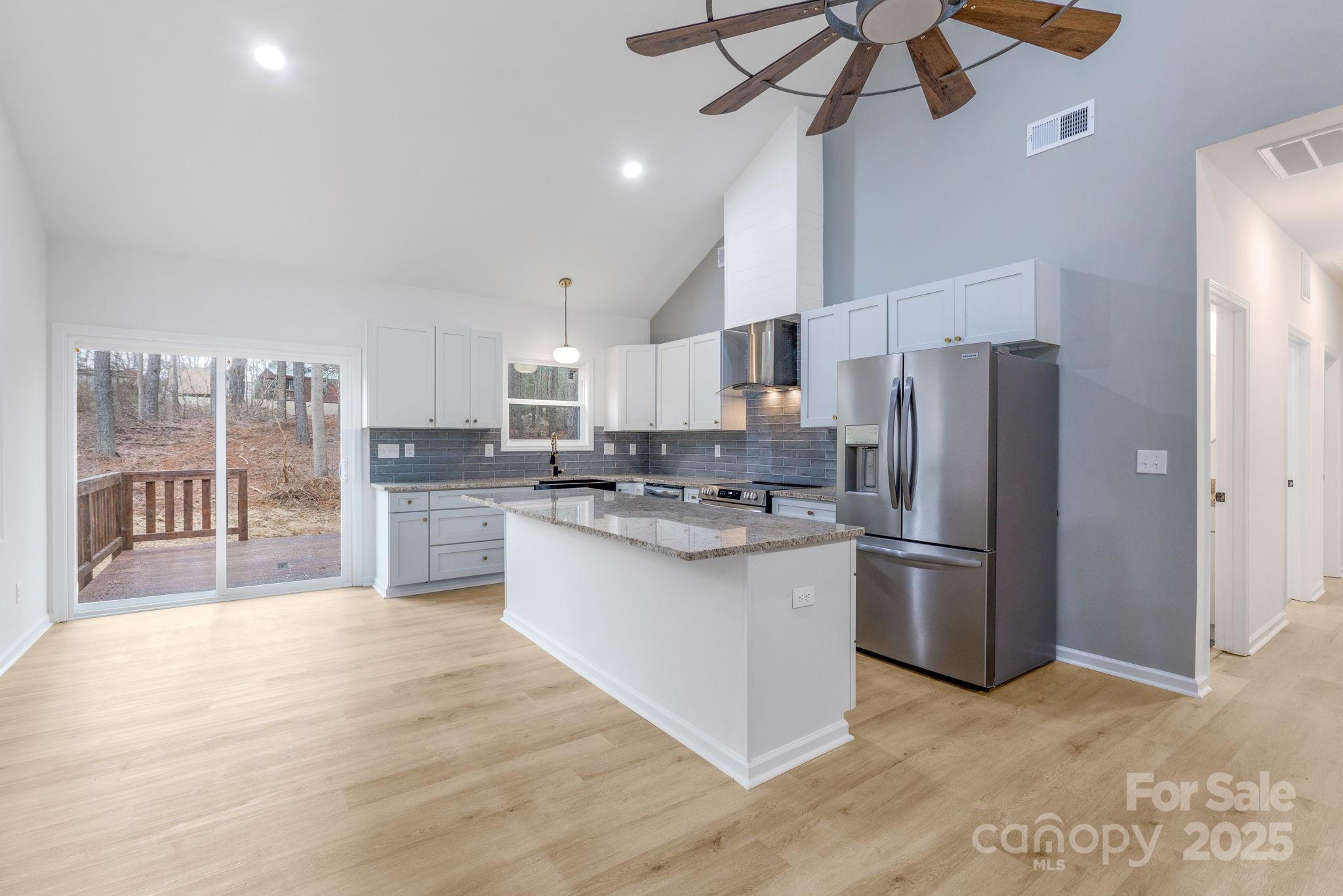 203 Bud Black Road Crouse, NC 28033 - Photo 24 of 47 a kitchen with stainless steel appliances a refrigerator a sink dishwasher a stove and white cabinets with wooden floor