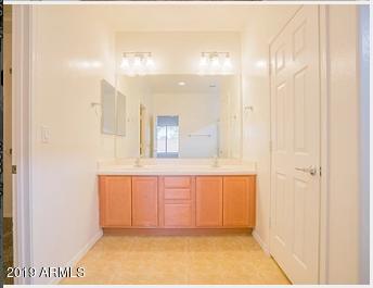 26132 West Burnett Road Buckeye, AZ 85396 - Photo 19 of 22 a bathroom with a mirror and a shower