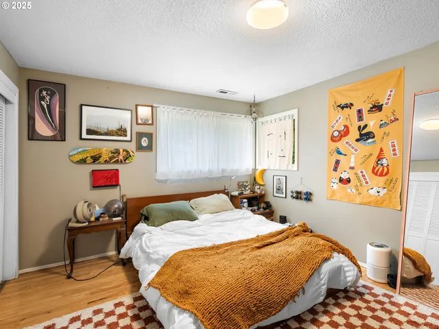 a bedroom with a bed and a painting on the wall