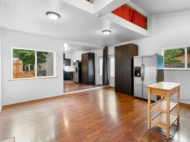 a kitchen view with stainless steel appliances kitchen island granite countertop a refrigerator and a stove top oven