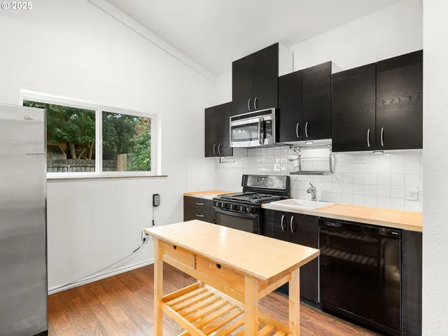 a kitchen with stainless steel appliances wooden cabinets and a stove top oven