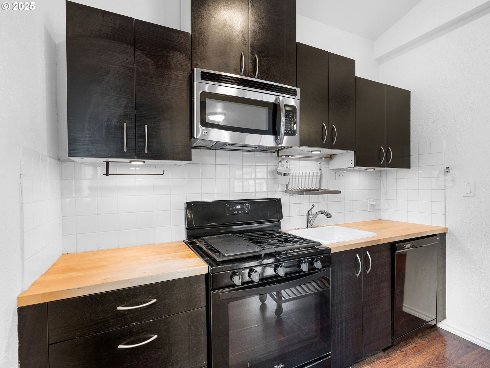 1245 Northeast 118th Avenue Portland, OR 97220 - Photo 24 of 35 a kitchen with stainless steel appliances wooden cabinets and a stove top oven