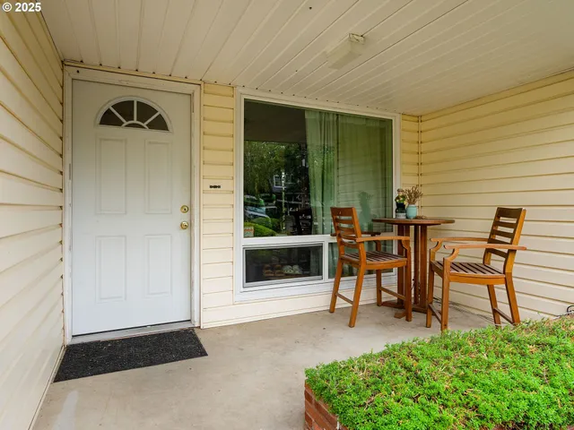a view of a porch with chairs and a yard
