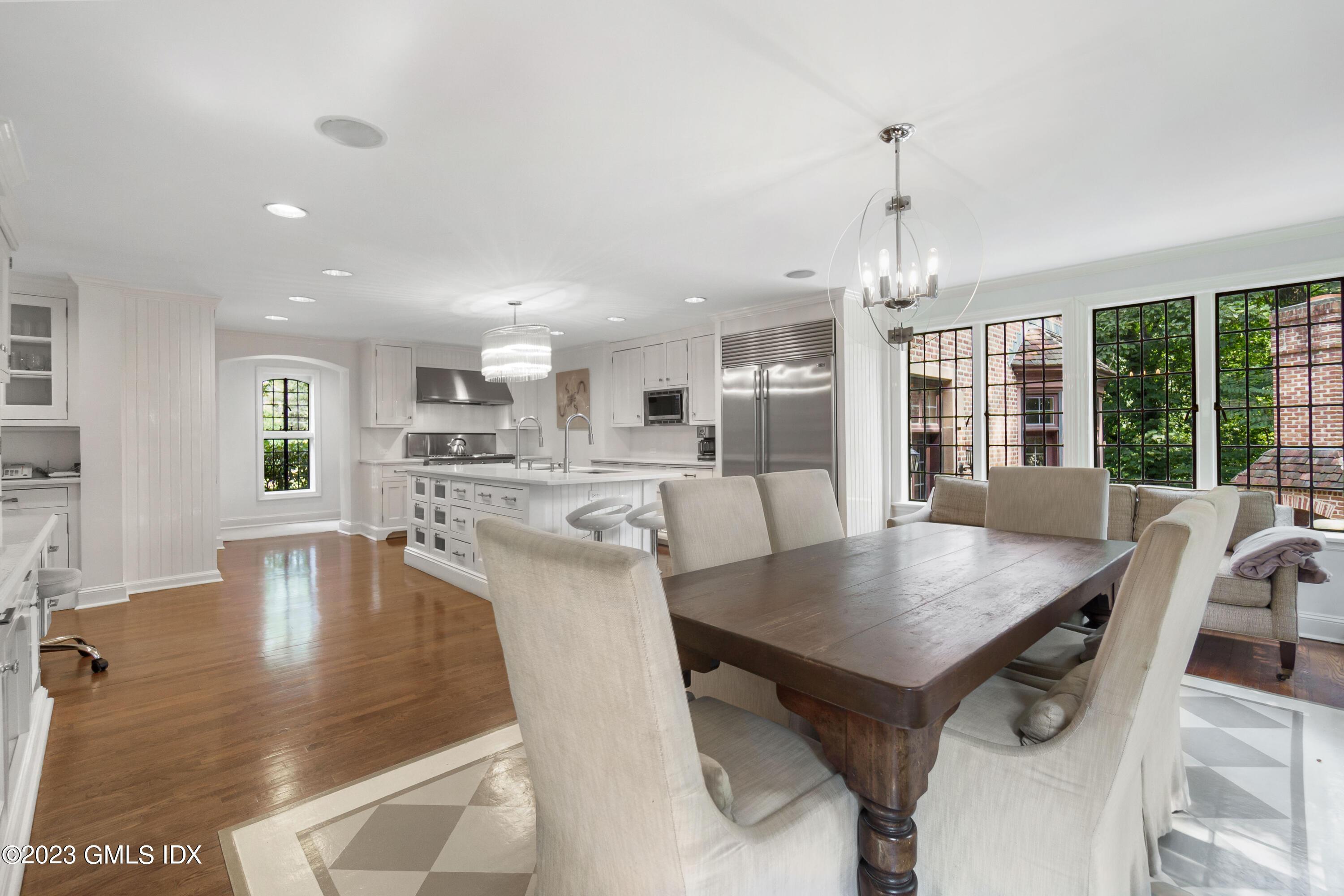 33 Midwood Road Greenwich, CT 06830 - Photo 9 of 22 a view of a dining room and livingroom with furniture wooden floor a rug a fireplace and a chandelier