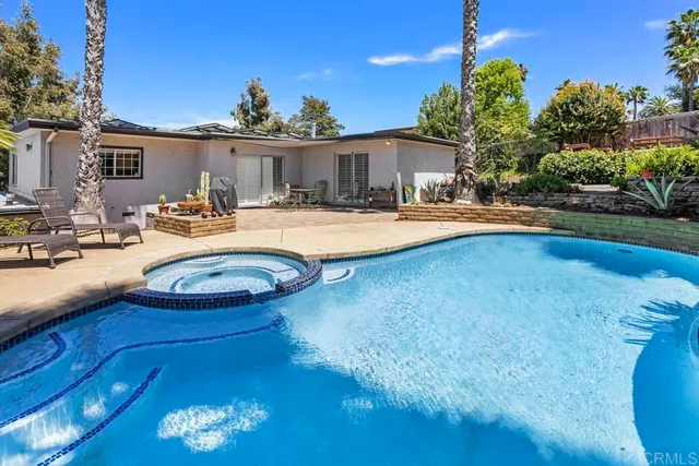a view of a house with swimming pool and a yard
