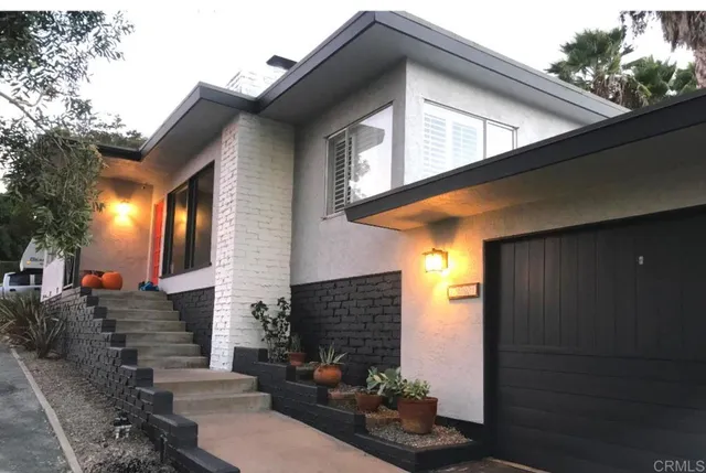 a front view of a house with plants