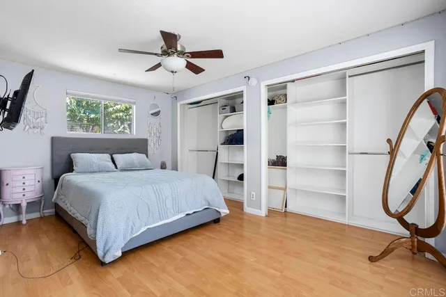 a bedroom with a bed a flat screen tv and a large window