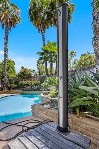a view of a swimming pool with lawn chairs under an umbrella