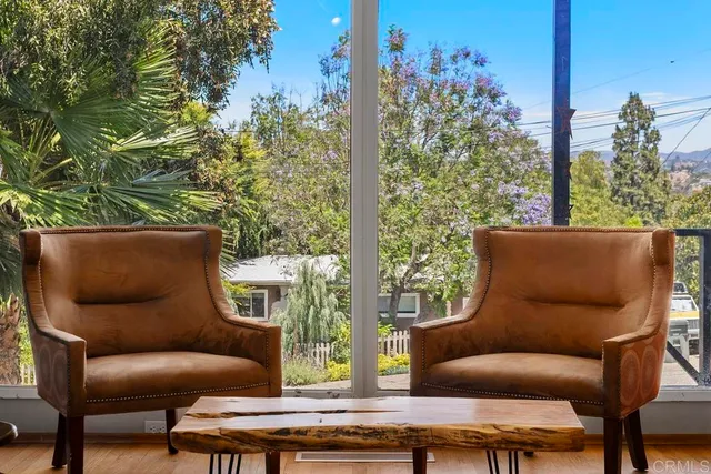 a living room with furniture a fireplace and a floor to ceiling window