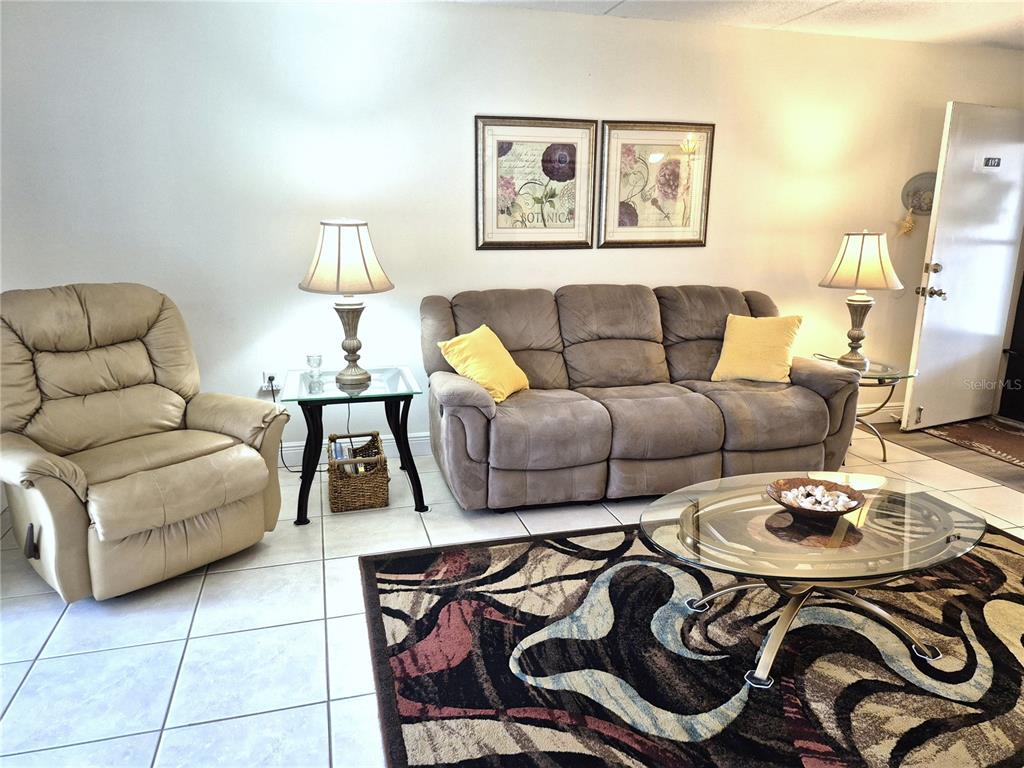 107 Windward Place, Unit 107 Oldsmar, FL 34677 - Photo 9 of 34 a living room with furniture a rug and a lamp