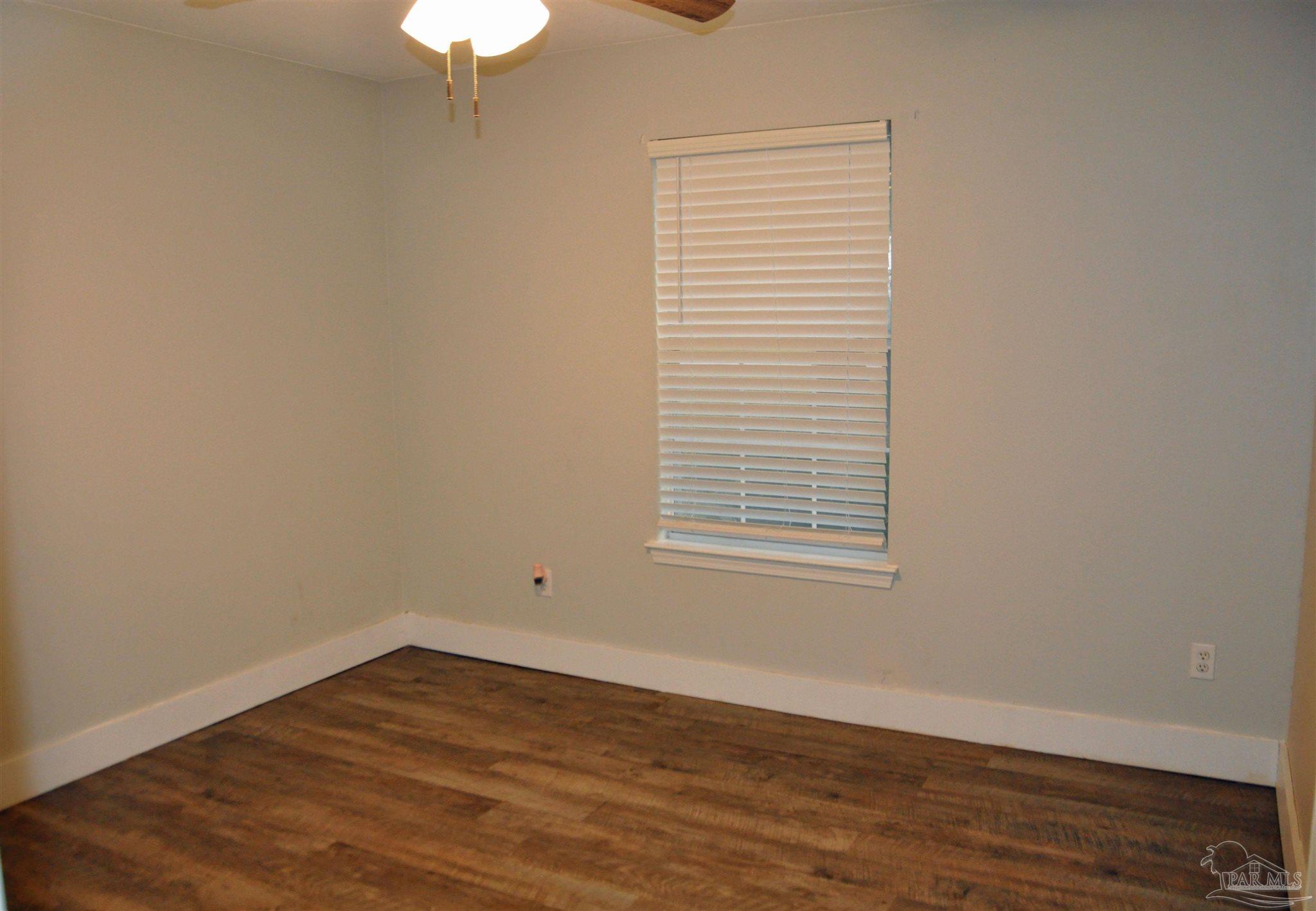 6623 Ridge Crest Drive Milton, FL 32570 - Photo 18 of 24 an empty room with wooden floor and windows