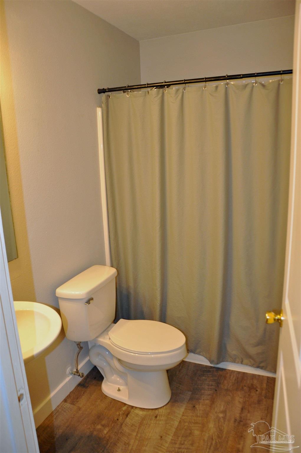 6623 Ridge Crest Drive Milton, FL 32570 - Photo 19 of 24 a white toilet sitting next to a shower curtain