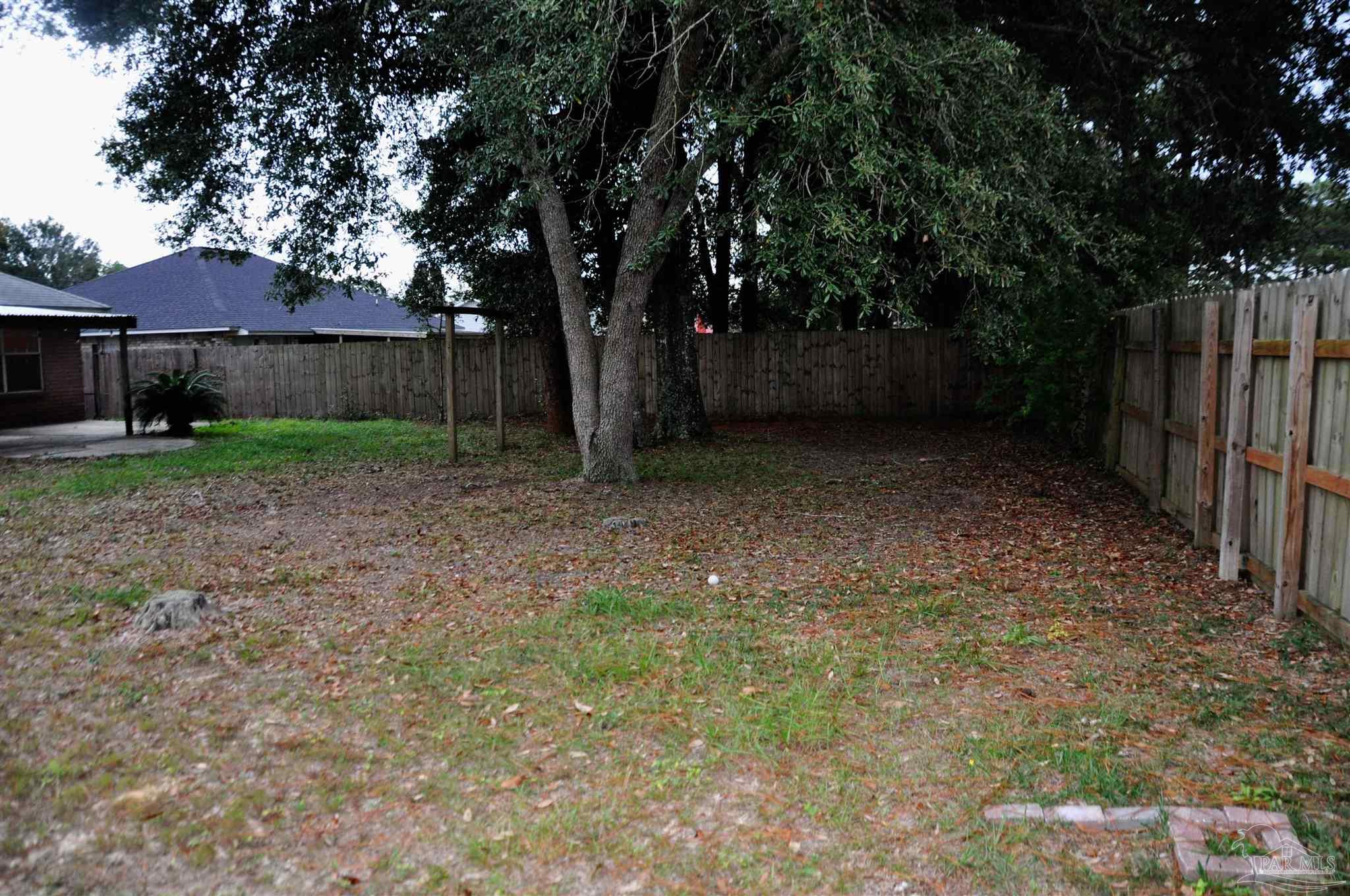 6623 Ridge Crest Drive Milton, FL 32570 - Photo 23 of 24 a view of a backyard with large trees and wooden fence