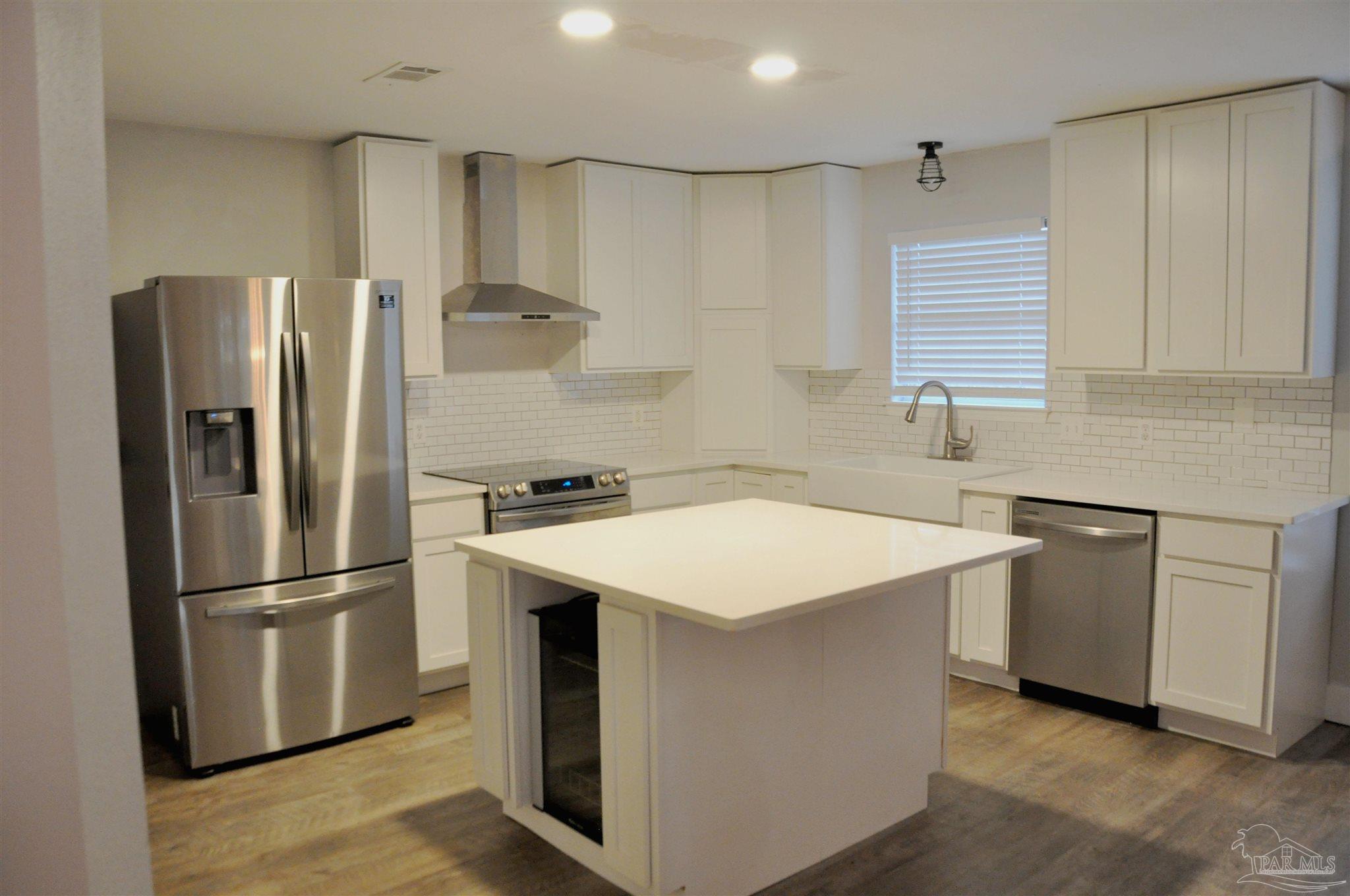 6623 Ridge Crest Drive Milton, FL 32570 - Photo 9 of 24 a kitchen with stainless steel appliances a refrigerator sink and cabinets