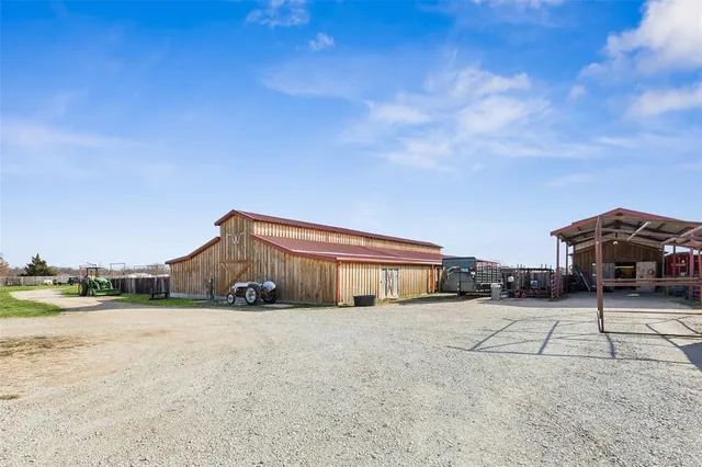a view of a house with a big yard and large trees