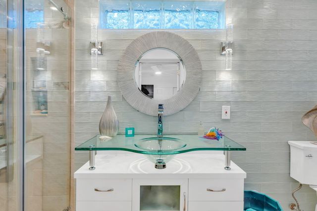 a bathroom with a granite countertop sink a toilet and shower