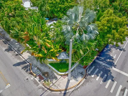 an outdoor sitting area with chairs and table under an umbrella